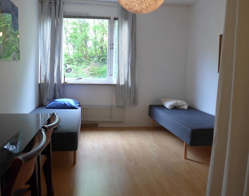 Sovrum med skrivbord och två sängar.