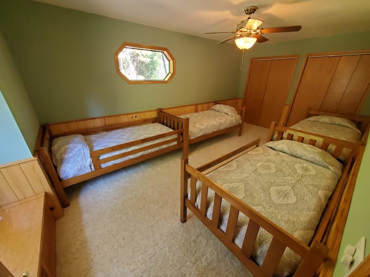 חדר שינה בקומה השלישית עם ארבע מיטות נפרדות.