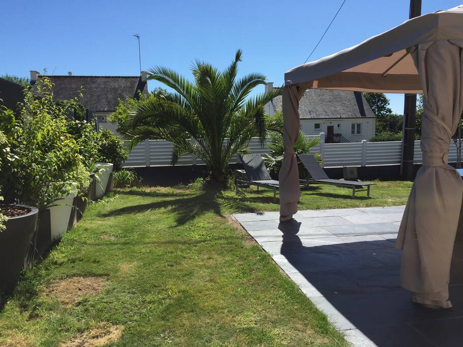 Jardin paysagé avec salon, et transats