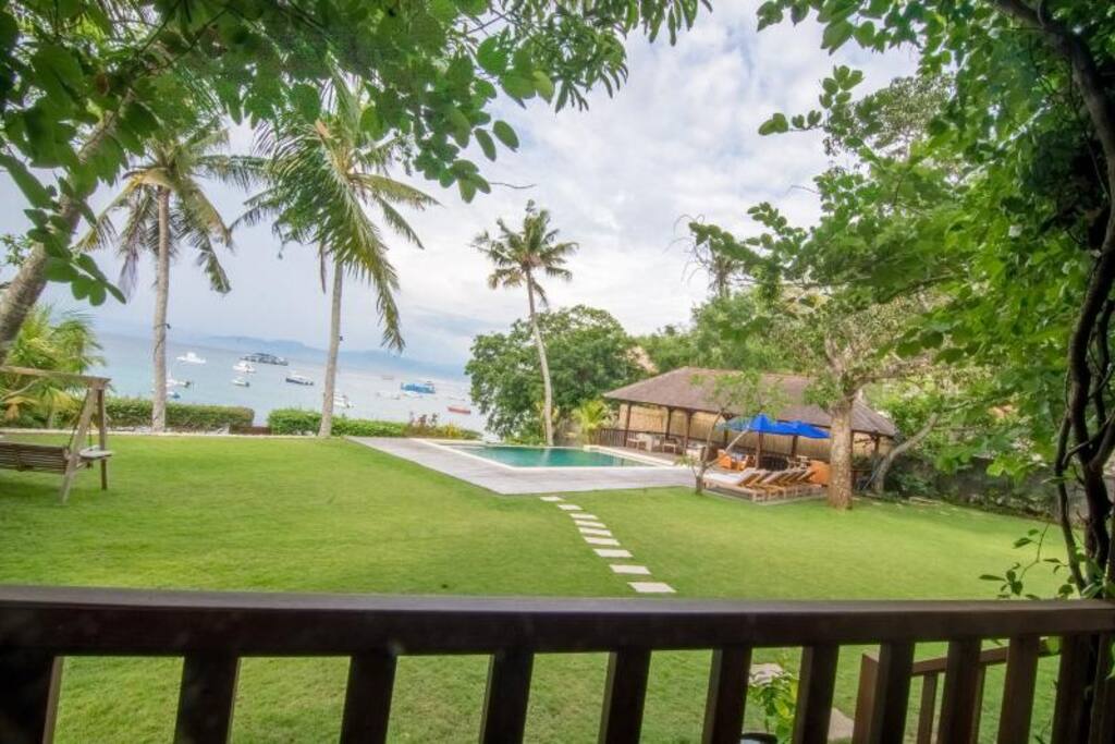 View from house deck to grass, pool and ocean