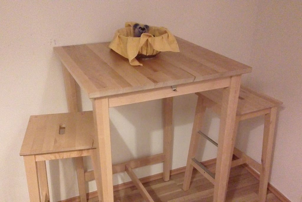 Tisch mit 2 Barhockern.