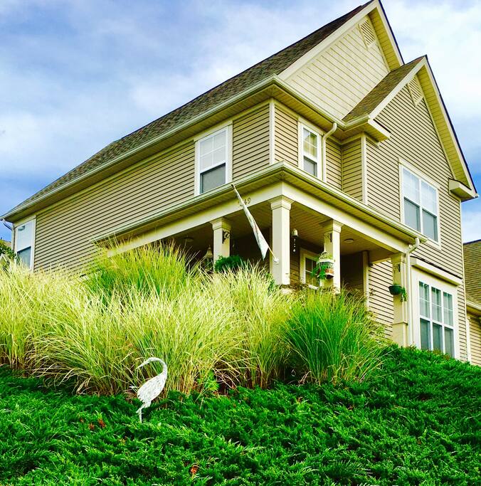 View of my home from the street with lots of ornamental grasses and flowers.