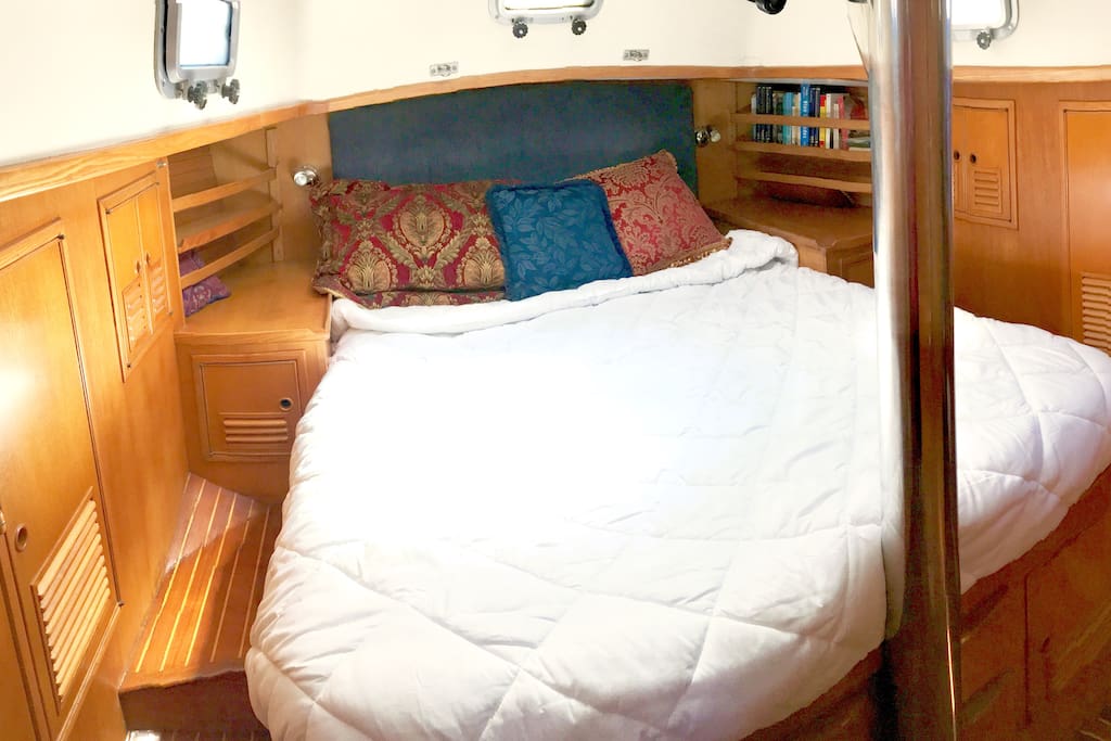 Queen berth in master stateroom. 5 opening portholes, and a large deck hatch overhead.