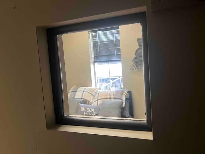 Dirisha la kufurahisha la peek-a-boo kutoka kwenye kabati la kuingia katika mojawapo ya vyumba vya kulala.