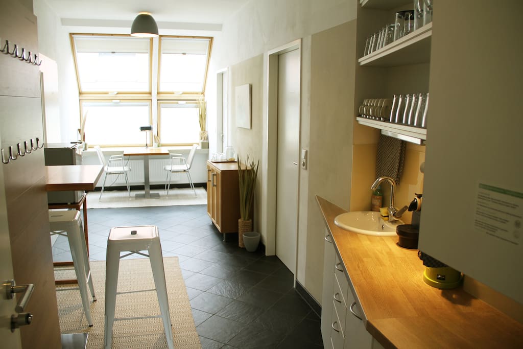 Minimalistische Küche mit Geschirr und kleinem Kühlschrank