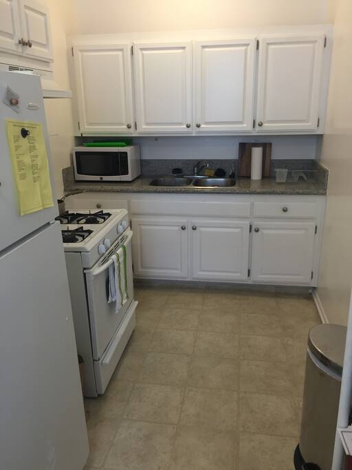 huge kitchen with microwave, stove/oven, refrigerator, & hot/cold water dispenser.