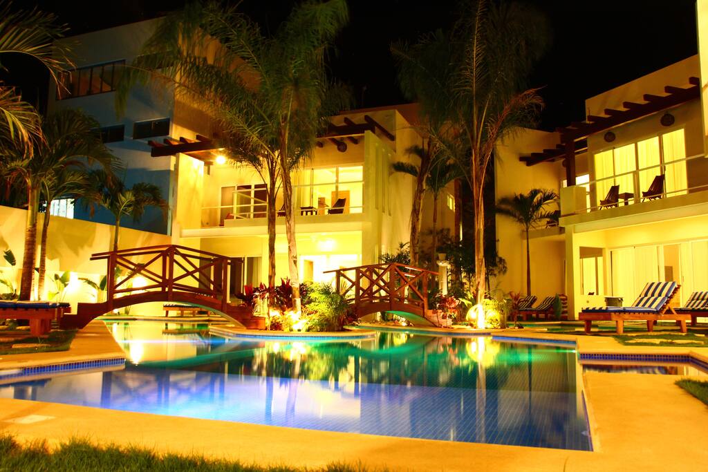 VISTA DE LA PISCINA Y DE LAS CASAS VECINAS EN LA NOCHE.
