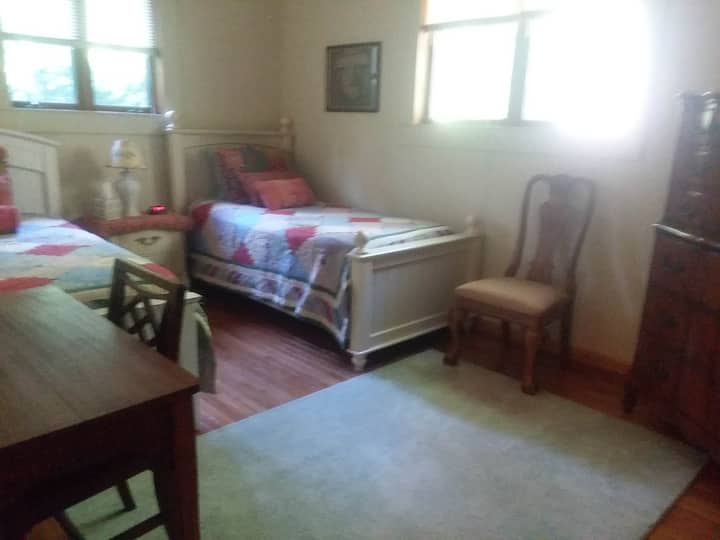 Dhomë gjumi dyshe shumëngjyrëshe me komodinë dhe tavolinë pune.