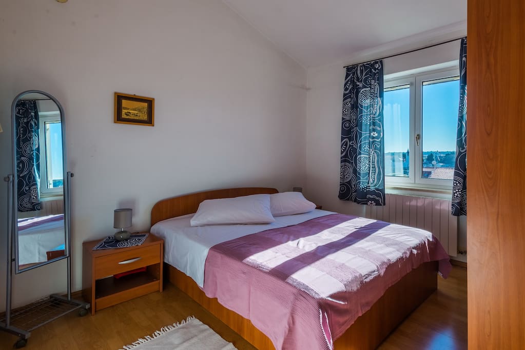 Spacious bedroom with double bed, closet and nightstands.