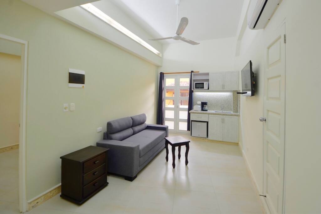 Living area with balcony, kitchenette, sofabed, TV & full bath