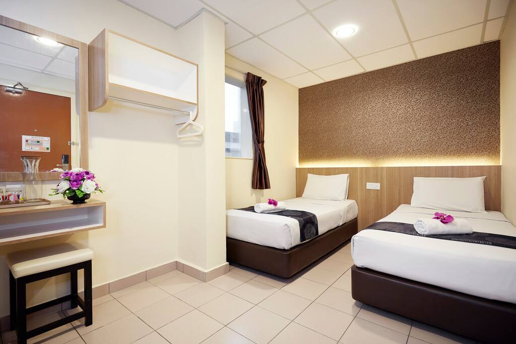 This is our Deluxe Twin Room. It comes with fitted bathroom, shower and WC, flat screen TV, cable TV, air-conditioning, working desk, vanity mirror, free drinking water. Bathroom amenities are provided, hair dryer and ironing facilities are on request.