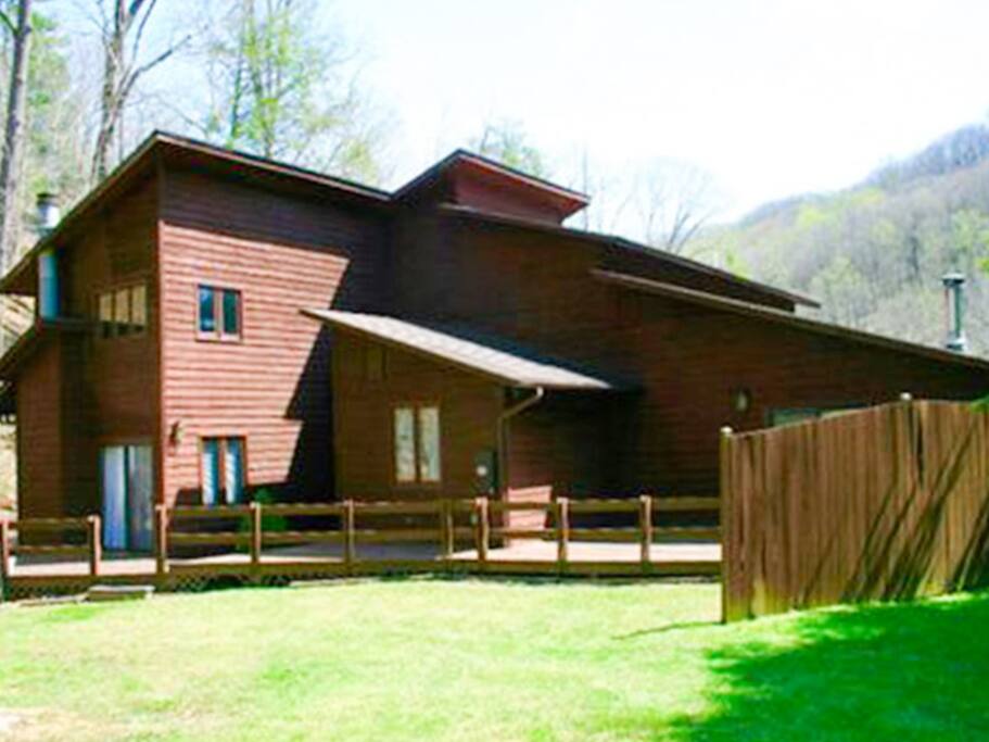 Back of home offers deck space and yard that borders the creek