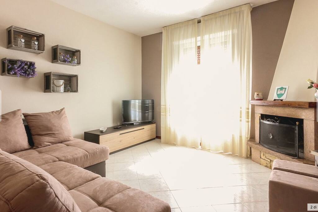 Salotto con divano letto, camino e televisore