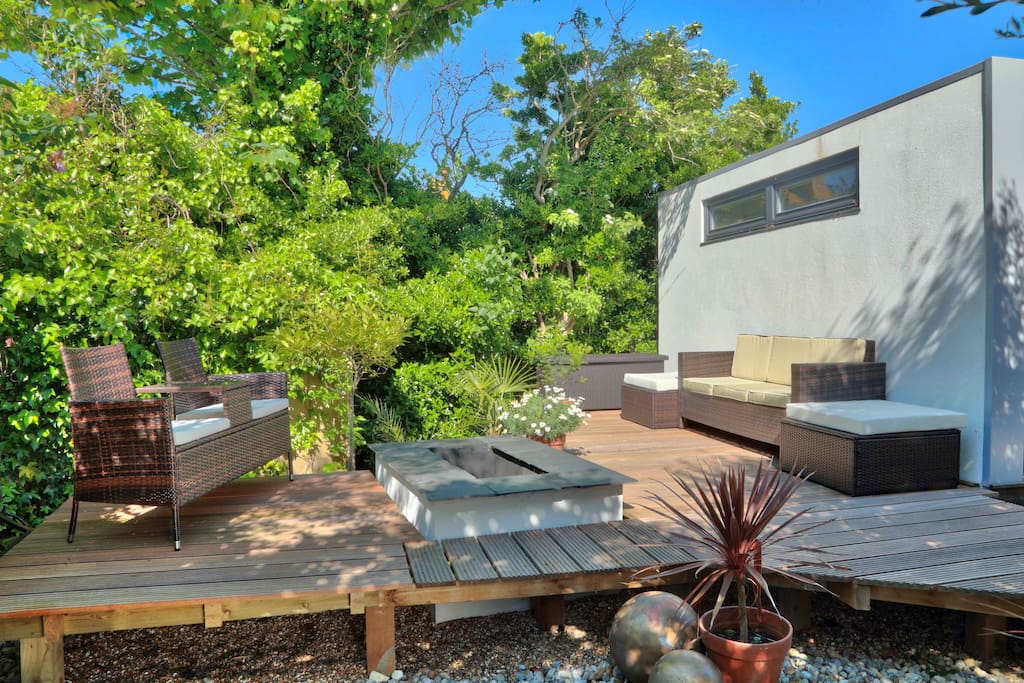 Decked seating area with a fire pit and breakfast table.
