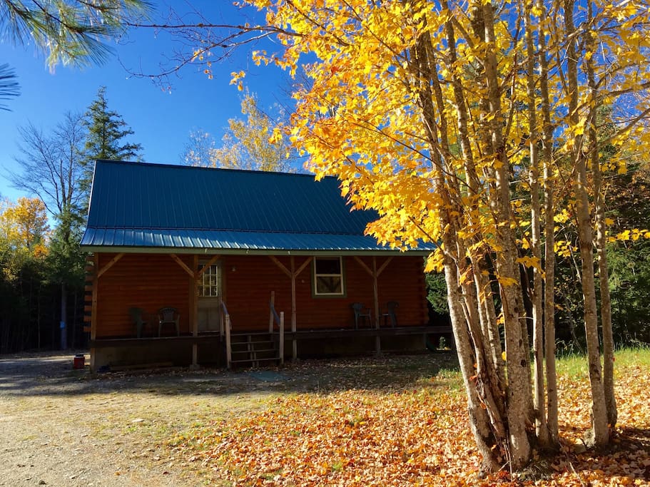Log cabin with large front porch. Woods all around the open clearing for a private setting on seven acres.