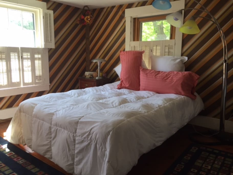 Queen bed with stunning morning light. Luxury bedding.