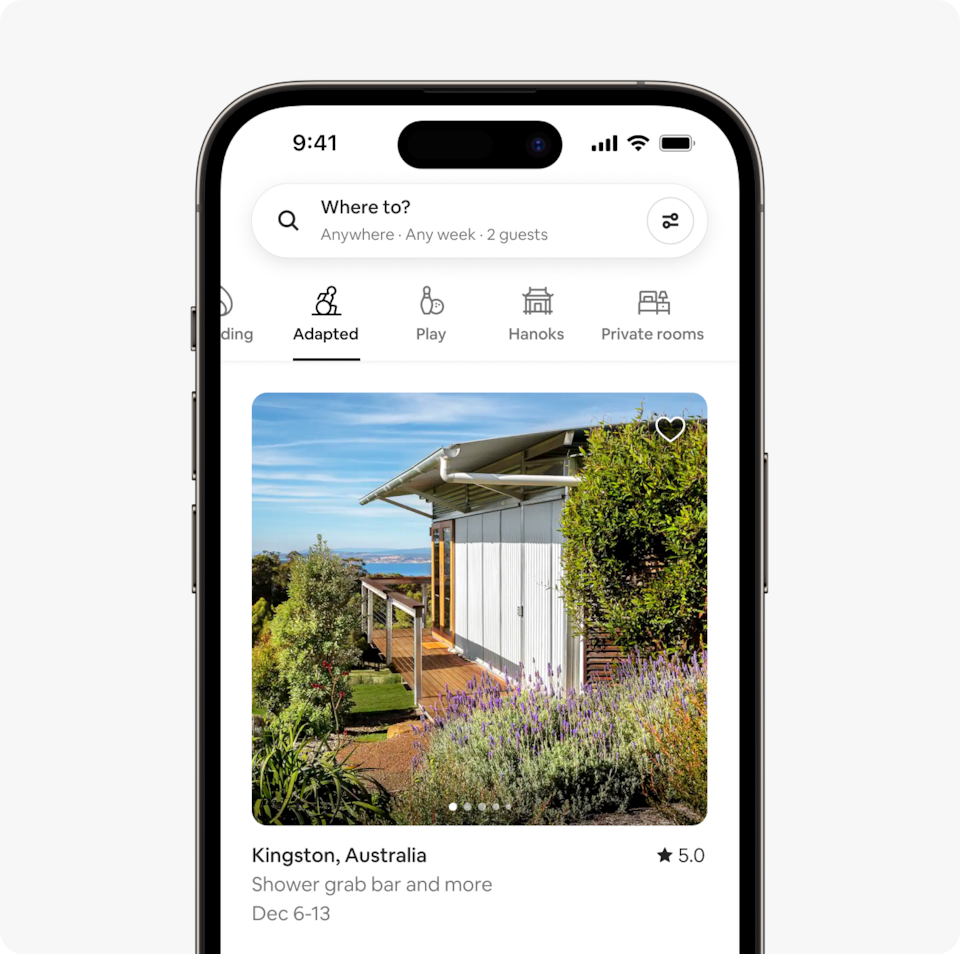 A laptop and a phone show the Airbnb homepage with two rows of homes from a new Airbnb Winter Release category called Adapted, which features wheelchair-accessible homes that have confirmed step-free access to the bedrooms and bathrooms.