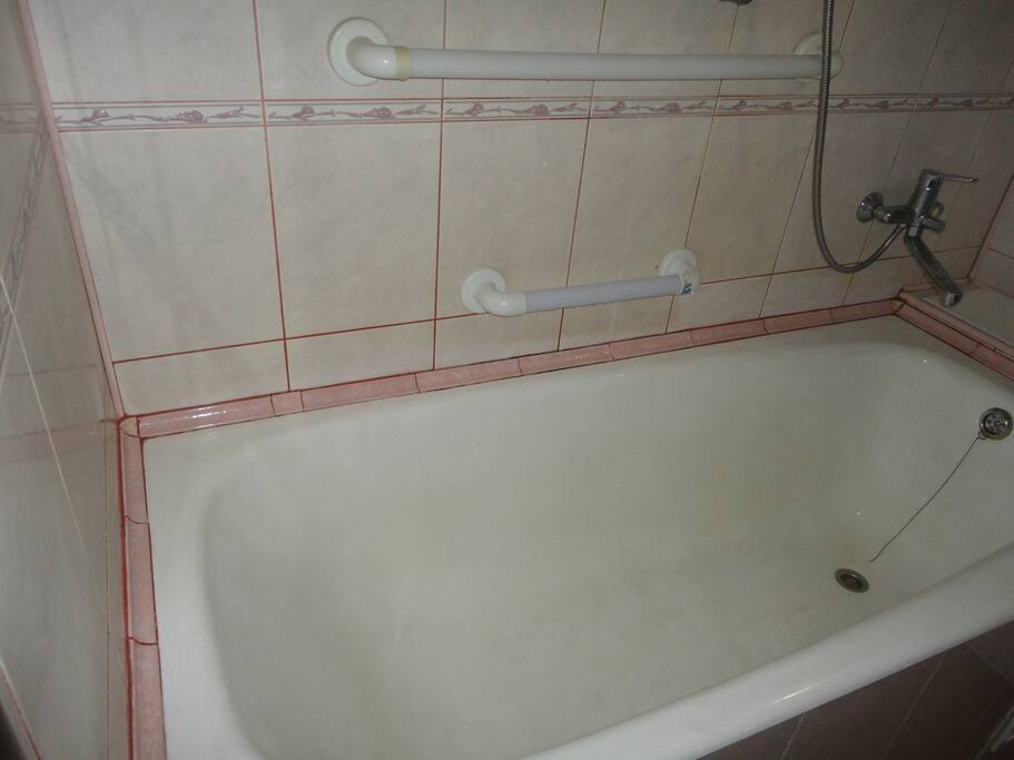 Ванная комната с розовой керамической плиткой, горячая и холодная вода хорошего качества, современные сантехника и трубы.