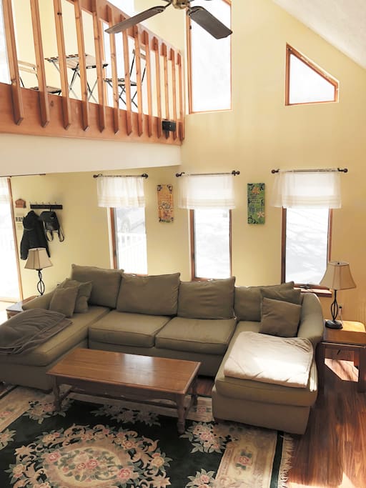 Brightly lit, full and spacious living room with a great view from the loft. Complete with a wood-burning fireplace.