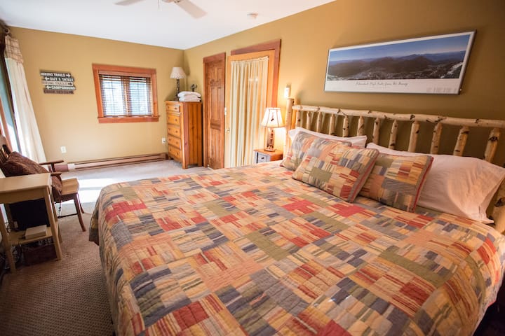 キングサイズのベッドとスイートバスルームを備えたメイン階のベッドルーム