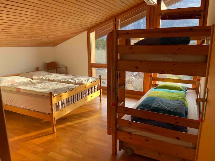 Yläkerran makuuhuone, jossa on kerrossänky ja queen-size-vuode