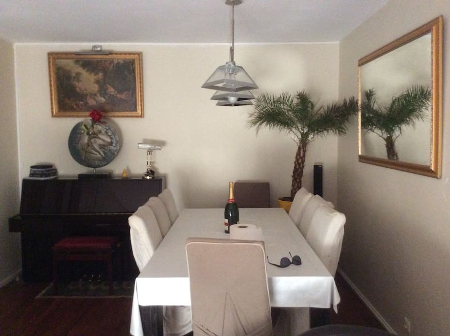 Salon vue sur le piano , la table de repas et le miroir