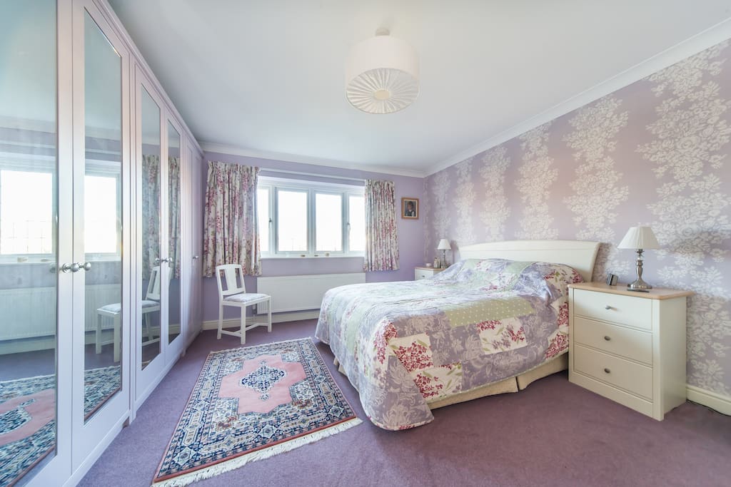Saffron double bedroom with King size bed, mirror wardrobes and calm decor.