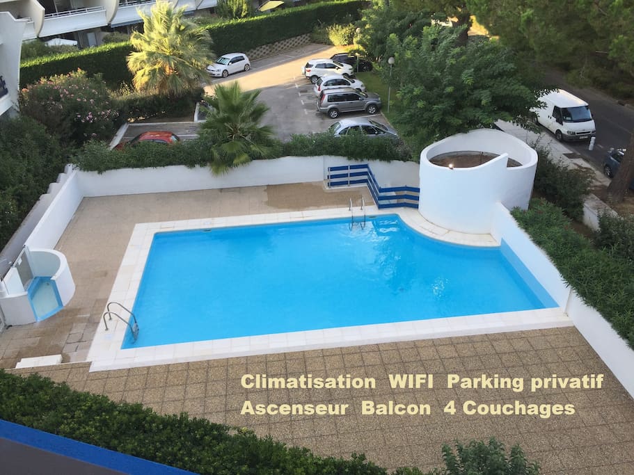 Vue de la piscine et du parking privatif depuis le balcon.