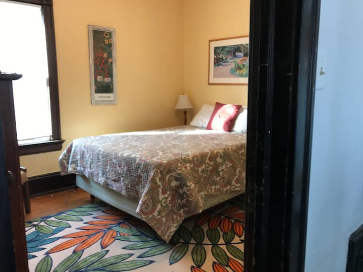 Pon los pies en alto para un buen descanso nocturno en el soleado dormitorio queen.