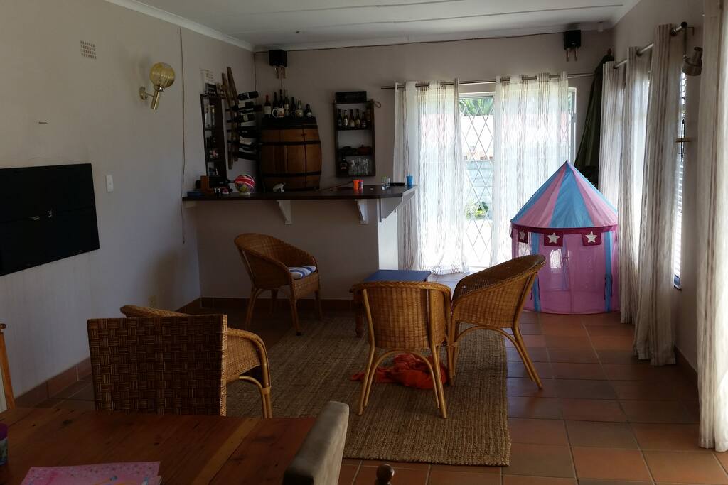 Open plan living with Bar area and BBQ indoors, doors to garden area.