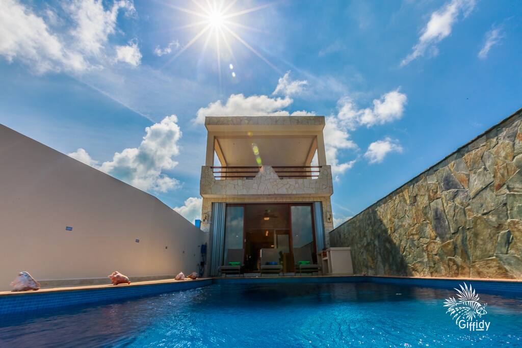 Sitting at the edge of the infinity pool, overlooking the beautiful waters of the Caribbean sea, looking back towards the house.