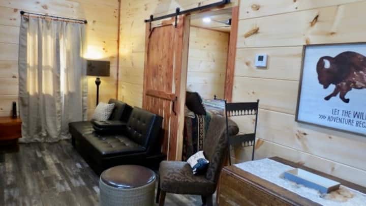 Living area with futon, chair with ottoman, Smart TV. Puzzles, cards, dominos, a few books provided.