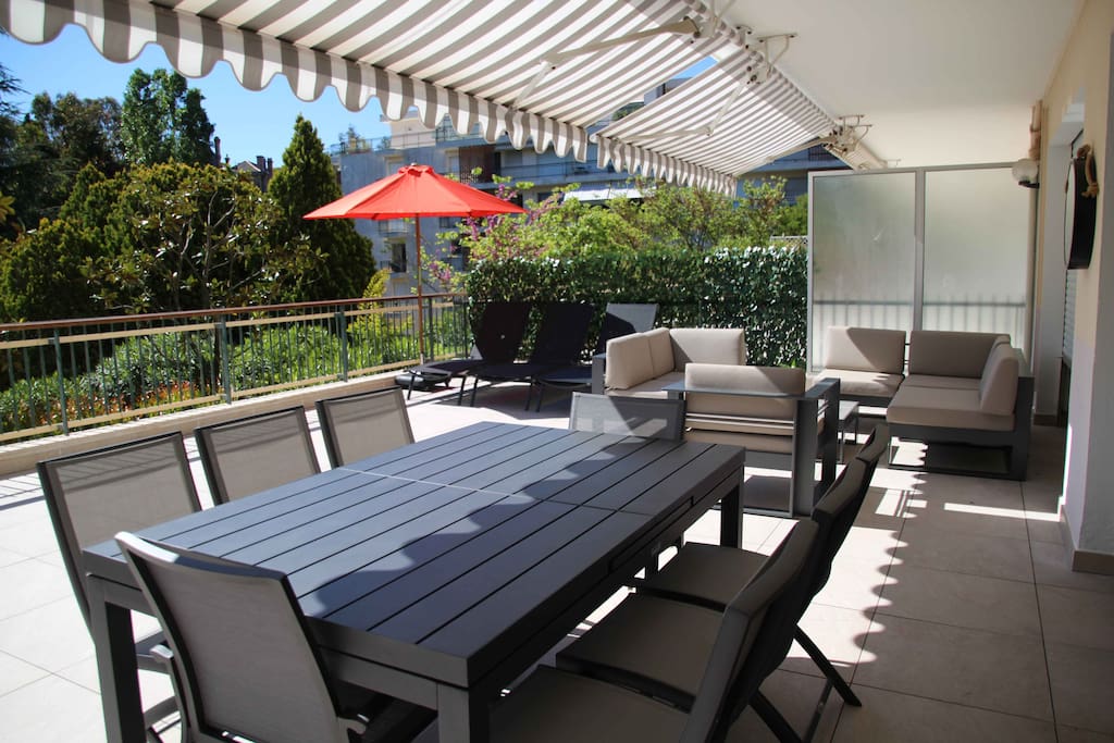 Salon extérieur, table avec 8 sièges et bains de soleil
