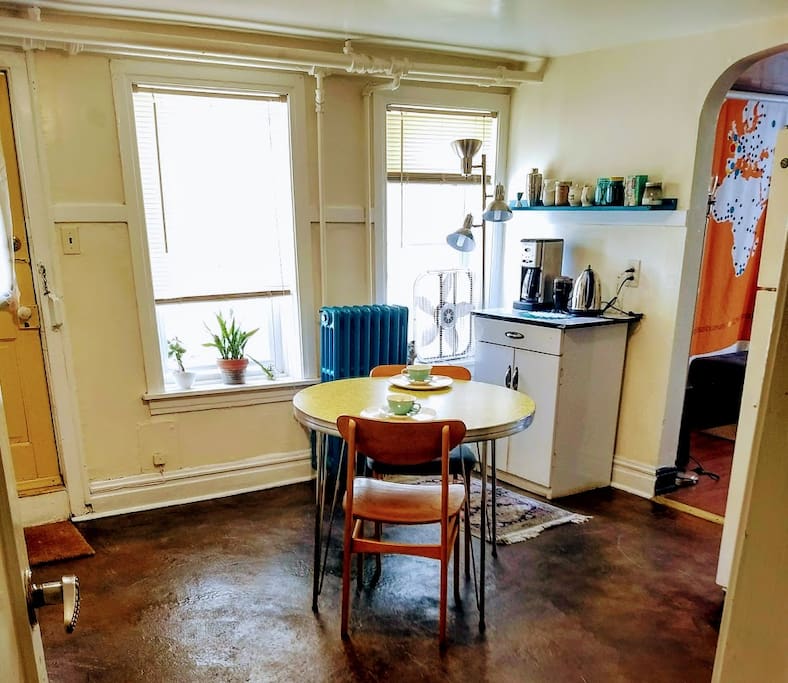 Mid-century modern kitchen, fully stocked coffee bar, with view into living room.