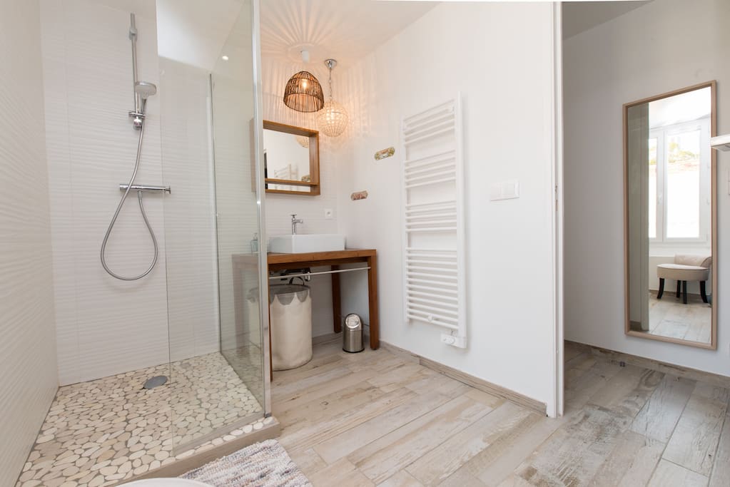 À côté de la chambre on trouve une Salle d’eau claire, avec sa douche à l’italienne en galets - douchette écologique . Elle comprend une fenêtre et des toilettes séparées.