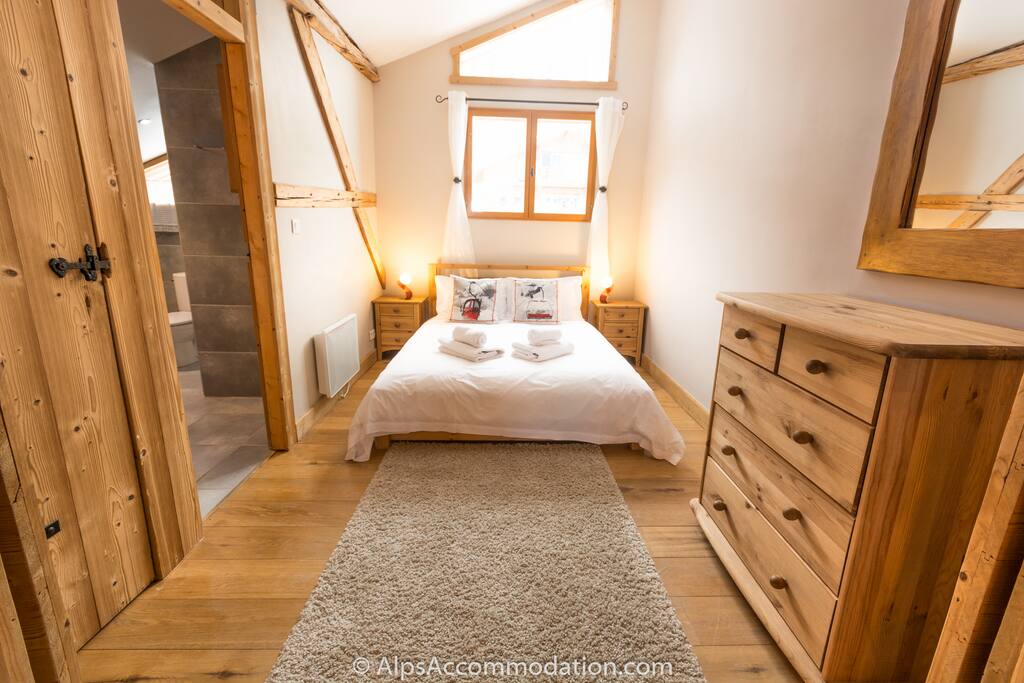Beautiful ensuite master bedroom featuring exposed beams and a high ceiling