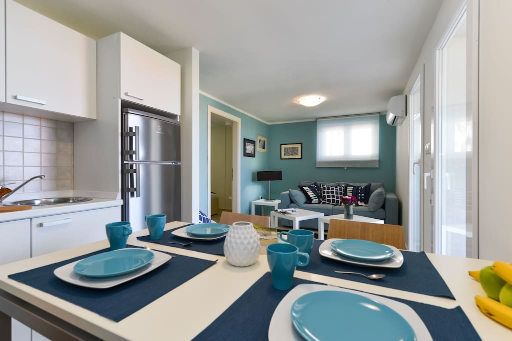 Dining table, kitchen and living room with two-seat sofa-bed