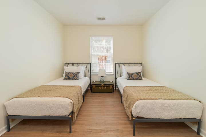 تحتوي غرفة النوم هذه على سريرين صغيرين ومصباح للإضاءة الإضافية.