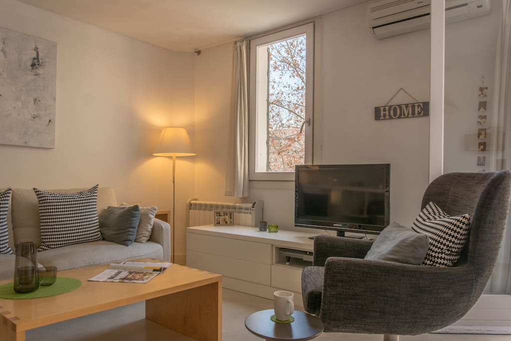 light and spacious living room with comfortable seating and television