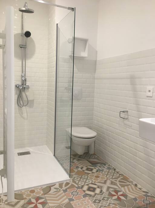 Salle d'eau avec grande douche et machine à laver