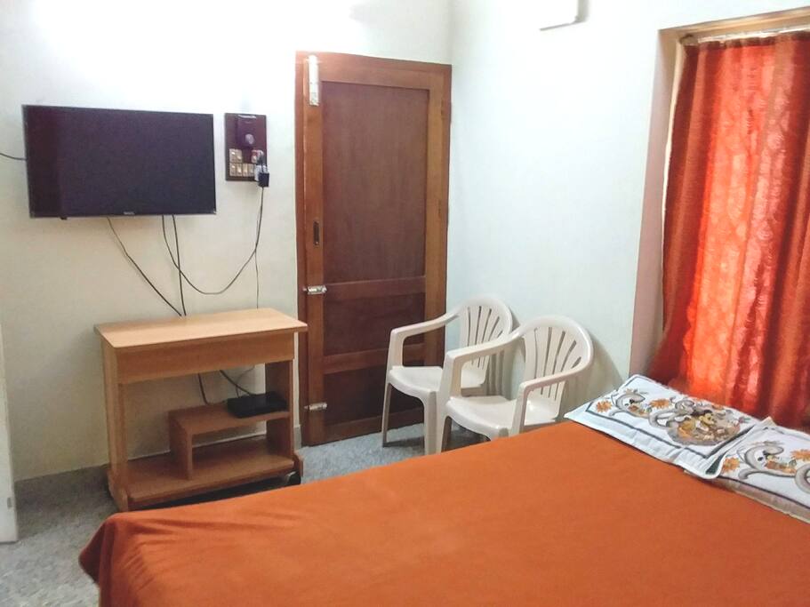 AC bedroom:TV, laptop table, chairs, door to sitout, bed