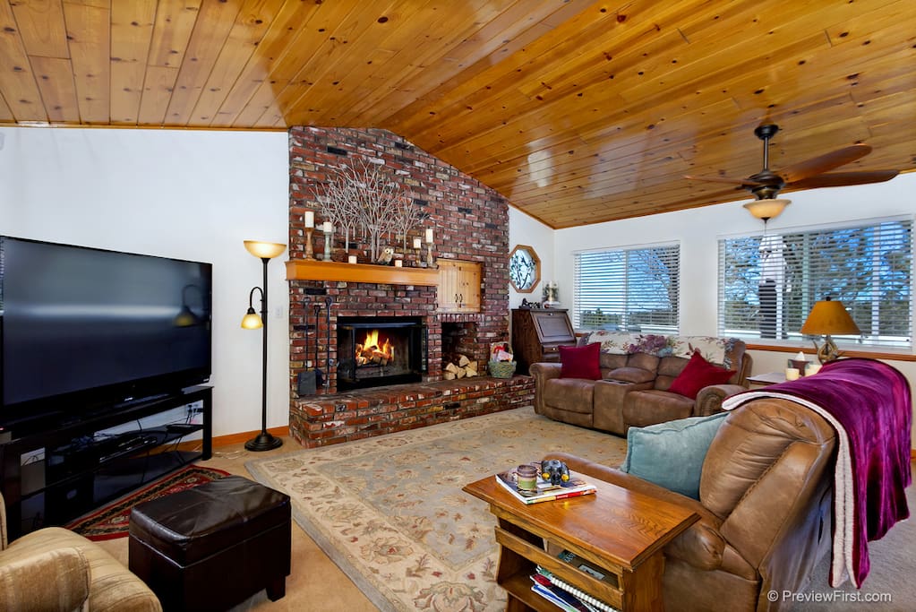 Living room with warm fireplace and large screen tv.