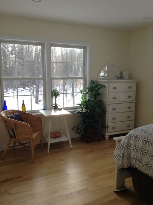 Lovely private bedroom located on the back end of the house secluded by a hallway off the main living room. View of back woods through all windows.