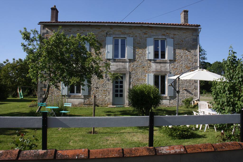 façade de la maison avec espace détente pour déjeuner et se reposer en bordure d'une rue des plus paisible