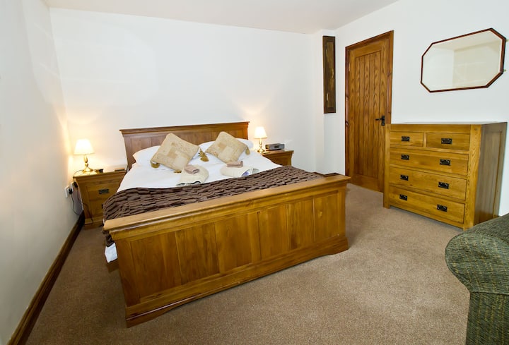 Საძინებლის ქვედა ნაწილში არის საკუთარი ტელევიზორი და მუხის დიდი ზომის საწოლი სააბაზანოს გვერდით, საშხაპეში გასეირნებით.