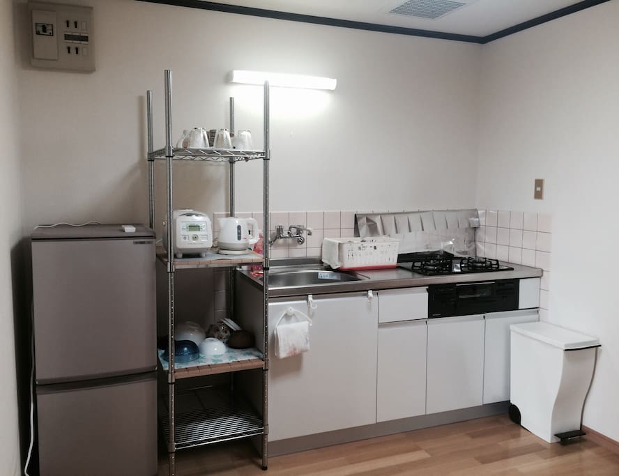 fully functional kitchen with refrigerator and utensals.