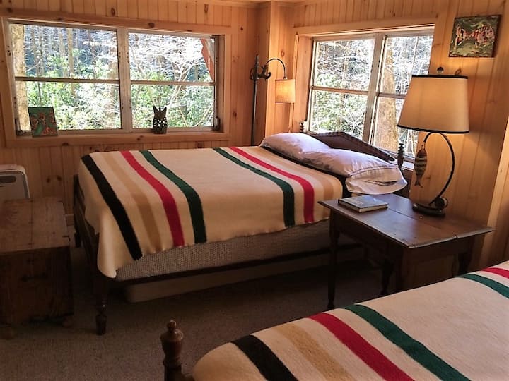 Esta habitación del nivel inferior ofrece mucho espacio para separarse y echar una siesta, las ventanas dan al arroyo.