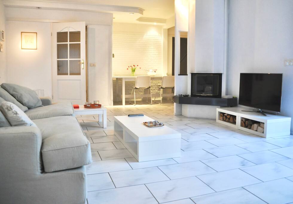 Woonkamer met haard en open keuken