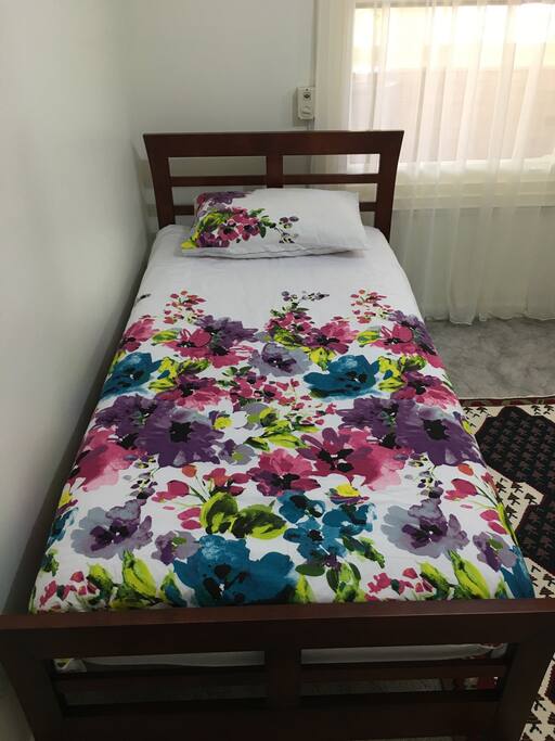 A brand new Wooden single bed with a comfortable almost new mattress and new beddings for your comfort.