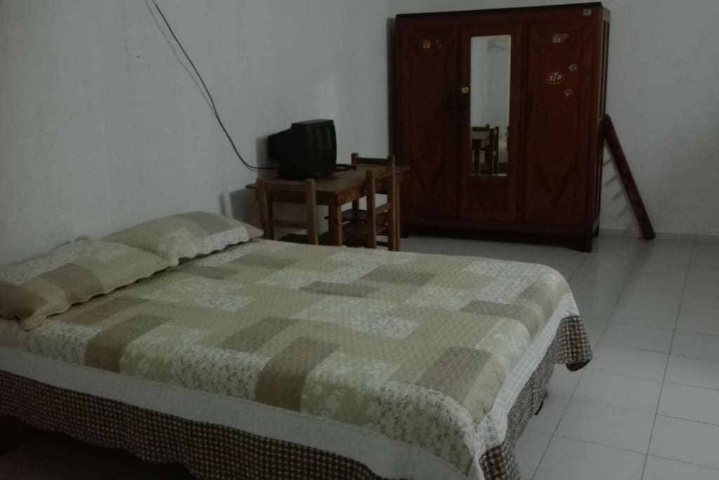 Tiene una cama matrimonial, una cama individual y una mesita para trabajar.
